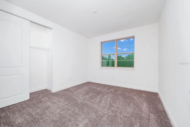 unfurnished bedroom featuring carpet flooring and a closet