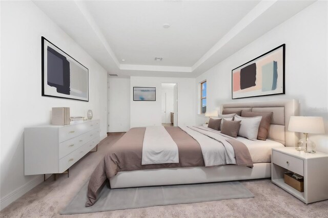 carpeted bedroom with a tray ceiling