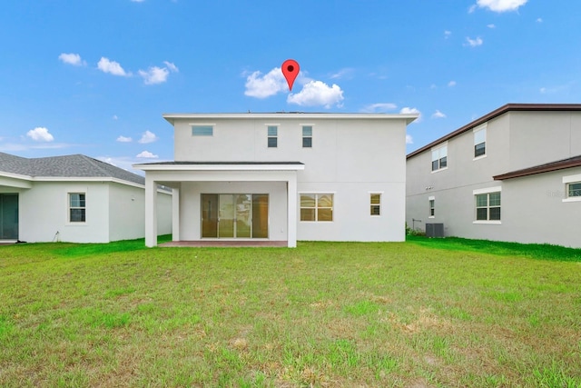 rear view of property featuring a lawn and cooling unit