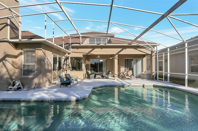 back of house featuring glass enclosure and a patio