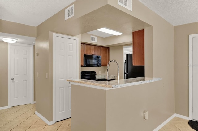 kitchen featuring black appliances, kitchen peninsula, a textured ceiling, and light tile patterned floors