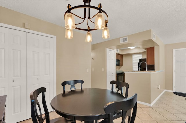 tiled dining space featuring a textured ceiling, a notable chandelier, and sink