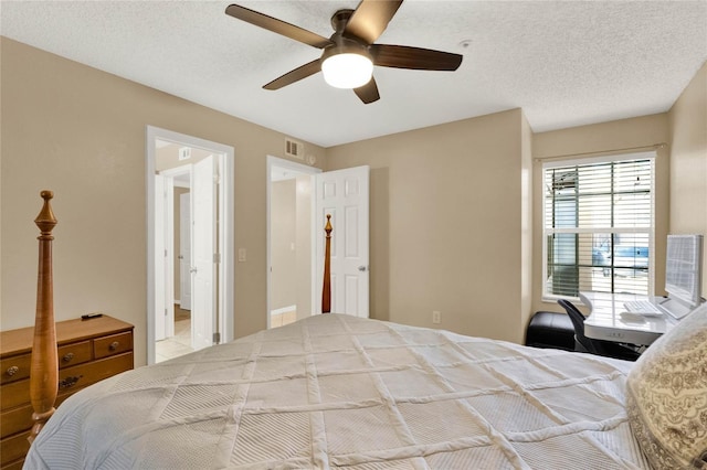 bedroom with ceiling fan and a textured ceiling