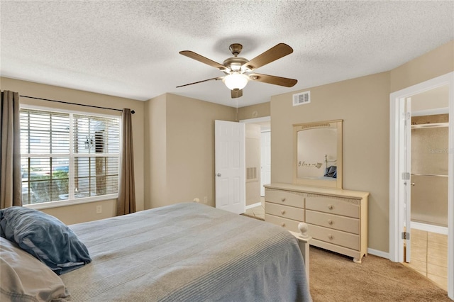 bedroom featuring light carpet, a textured ceiling, and ceiling fan