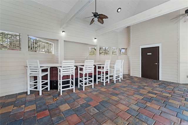 view of patio featuring ceiling fan and a bar