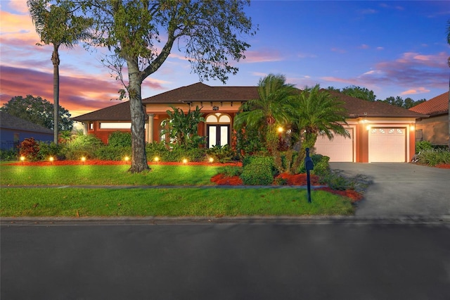 view of front of property featuring a lawn and a garage