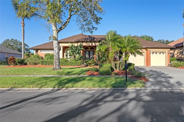 mediterranean / spanish-style home featuring a garage and a front yard