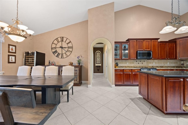 kitchen featuring high vaulted ceiling, pendant lighting, and an inviting chandelier