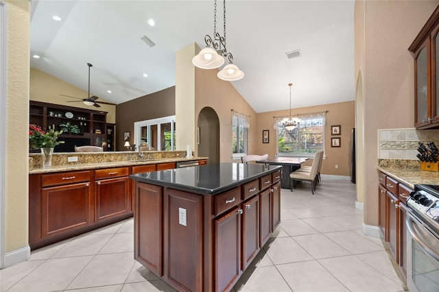 kitchen with pendant lighting, a center island, sink, light tile patterned floors, and gas stove