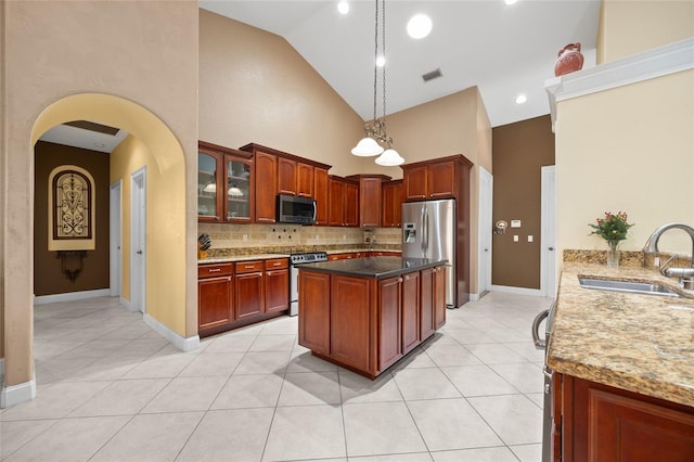 kitchen with sink, high vaulted ceiling, light tile patterned floors, and appliances with stainless steel finishes