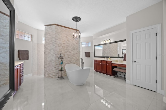 bathroom with vanity, a textured ceiling, a notable chandelier, tile patterned flooring, and a bathing tub