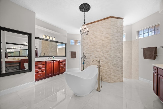 bathroom featuring tile patterned flooring, vanity, a tub to relax in, and an inviting chandelier