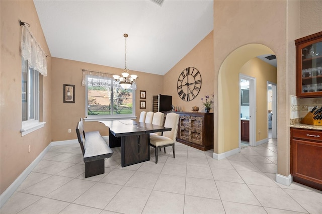 dining space with light tile patterned flooring, high vaulted ceiling, and an inviting chandelier