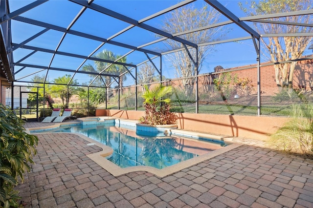 view of swimming pool with glass enclosure and a patio