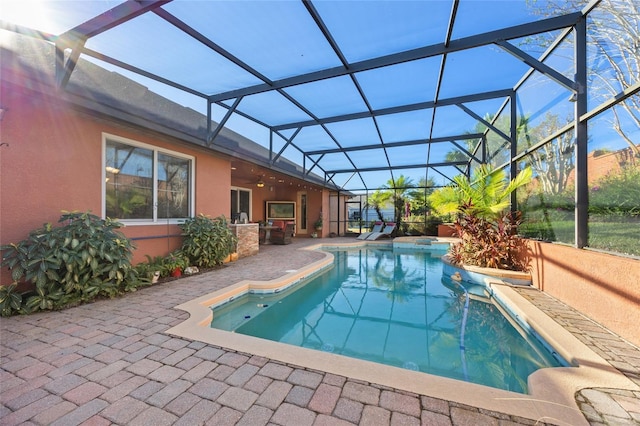 view of pool with ceiling fan, a lanai, and a patio