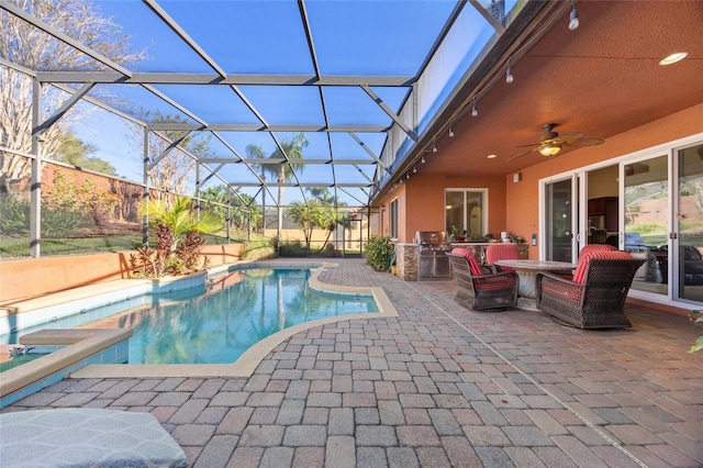 view of swimming pool with a lanai, a patio area, ceiling fan, and area for grilling