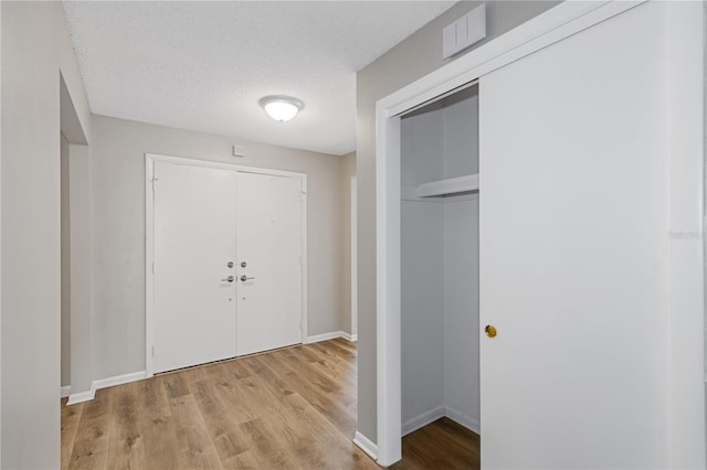 interior space featuring a textured ceiling and light hardwood / wood-style floors