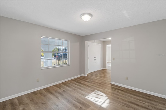 spare room with a textured ceiling and hardwood / wood-style flooring