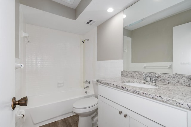 full bathroom with toilet, vanity, wood-type flooring, and tiled shower / bath