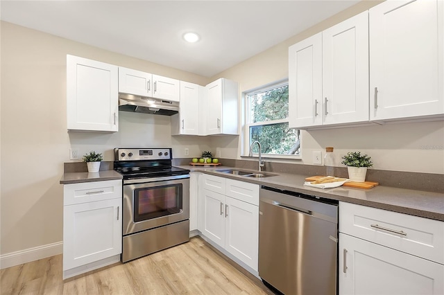 kitchen with white cabinets, light wood-type flooring, stainless steel appliances, and sink