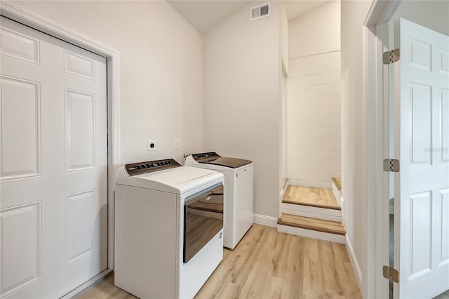 laundry room featuring washer and clothes dryer and light wood-type flooring