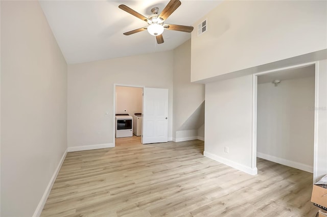 unfurnished bedroom featuring washer / dryer, high vaulted ceiling, light hardwood / wood-style flooring, and ceiling fan