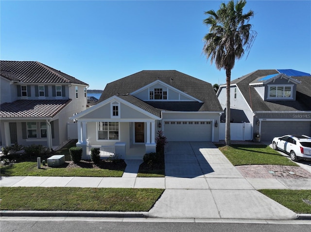 view of front of house featuring covered porch, a garage, and a front yard