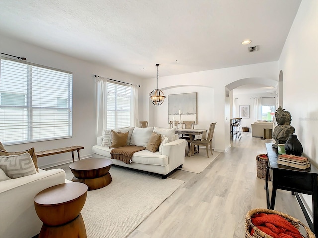 living room with light hardwood / wood-style flooring and a notable chandelier