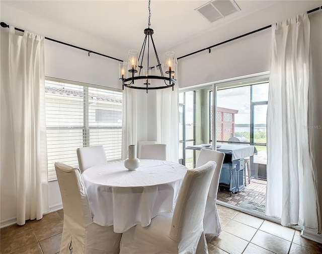 dining space with light tile patterned flooring and an inviting chandelier