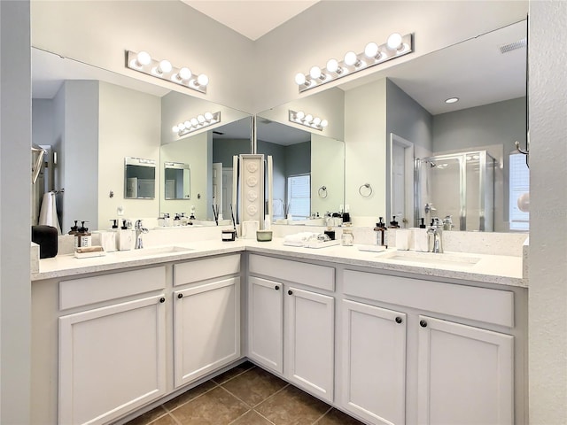 bathroom featuring tile patterned floors, a shower with shower door, and vanity