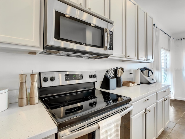 kitchen featuring white cabinetry, light tile patterned flooring, and stainless steel appliances