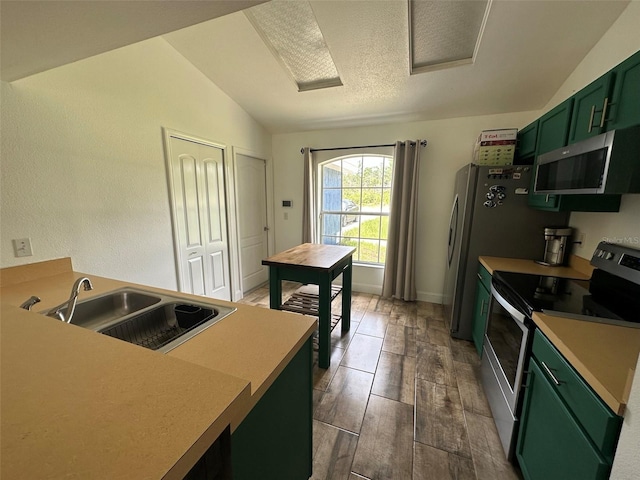 kitchen featuring lofted ceiling, sink, green cabinetry, dark hardwood / wood-style floors, and stainless steel appliances