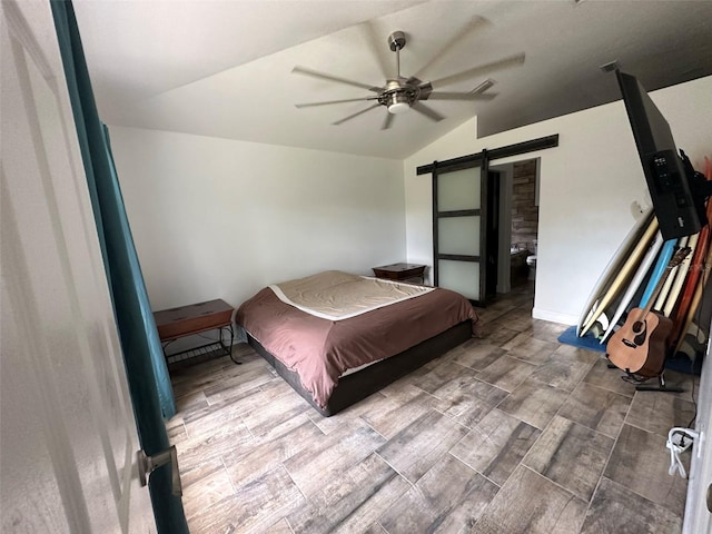 bedroom with ceiling fan, a barn door, wood-type flooring, and lofted ceiling