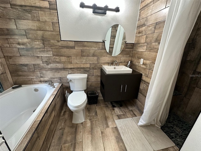 full bathroom featuring hardwood / wood-style floors, vanity, wooden walls, toilet, and shower with separate bathtub