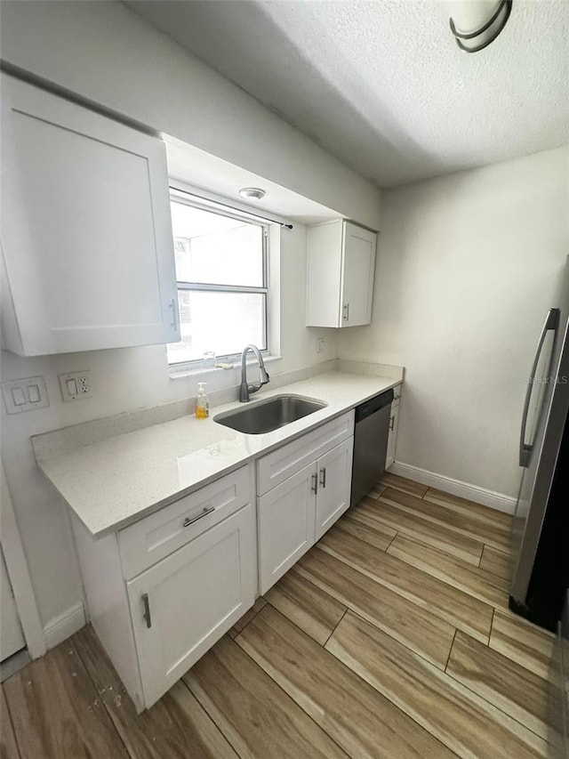 kitchen with white cabinetry, light hardwood / wood-style flooring, and stainless steel appliances