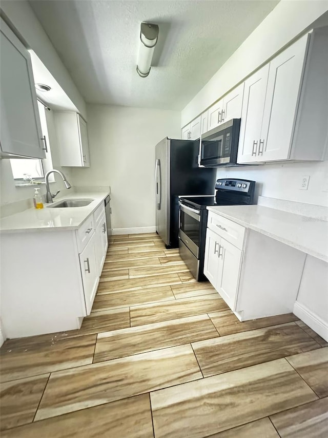 kitchen with sink, white cabinets, and stainless steel appliances