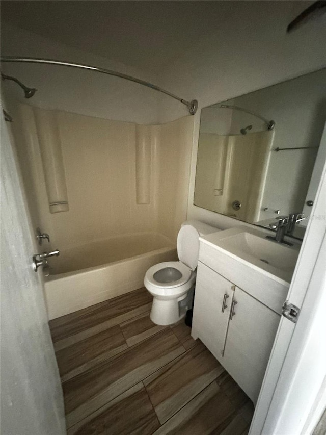 full bathroom with hardwood / wood-style flooring, vanity, toilet, and bathtub / shower combination