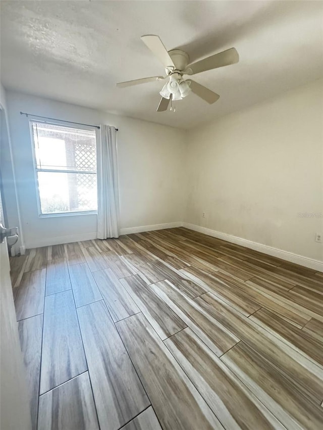 unfurnished room with ceiling fan and wood-type flooring