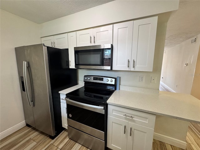 1234 Sago Palm Blvd Unit 1234, Kissimmee, FL 34741 - kitchen with stainless steel appliances, white cabinetry, light wood-style flooring, baseboards, and a textured ceiling