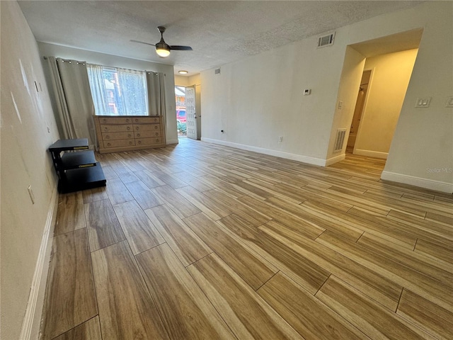 1234 Sago Palm Blvd Unit 1234, Kissimmee, FL 34741 - empty room with light wood-type flooring, ceiling fan, baseboards, and a textured ceiling