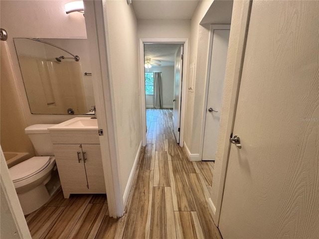 1234 Sago Palm Blvd Unit 1234, Kissimmee, FL 34741 - full bath featuring wood finished floors, vanity, baseboards, and toilet