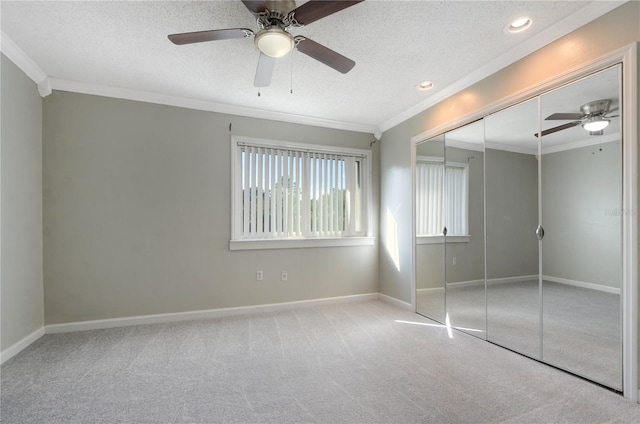 unfurnished bedroom with carpet, a closet, crown molding, and a textured ceiling