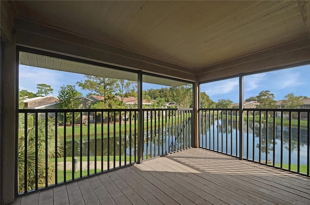 unfurnished sunroom featuring a water view