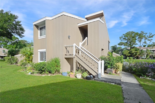 back of house with stairway and a lawn