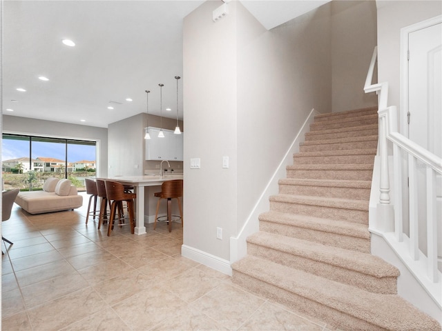 staircase featuring tile patterned flooring and sink