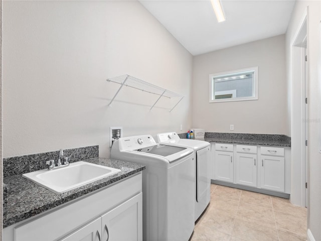 washroom featuring cabinets, sink, light tile patterned floors, and washer and dryer