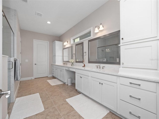 bathroom with tile patterned flooring, vanity, and a shower with door