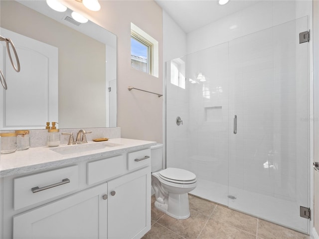 bathroom featuring tile patterned floors, a shower with door, vanity, and toilet