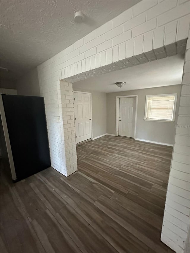 unfurnished living room featuring dark hardwood / wood-style floors and a textured ceiling