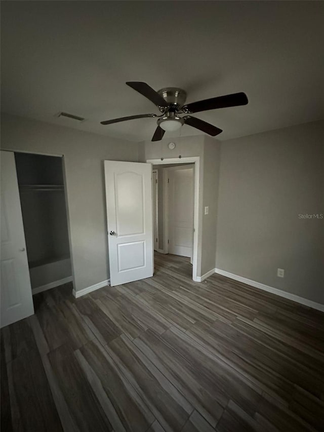 unfurnished bedroom featuring ceiling fan and dark hardwood / wood-style flooring